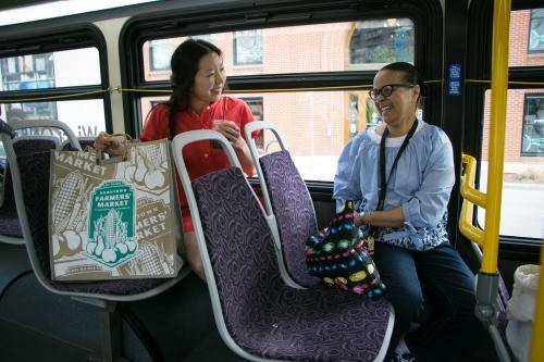 two women boarding bus to go to the downtown farmers market