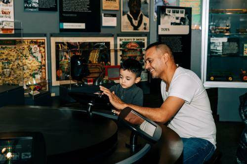 father and son interacting with an exhibit at the Iowa state historical museum